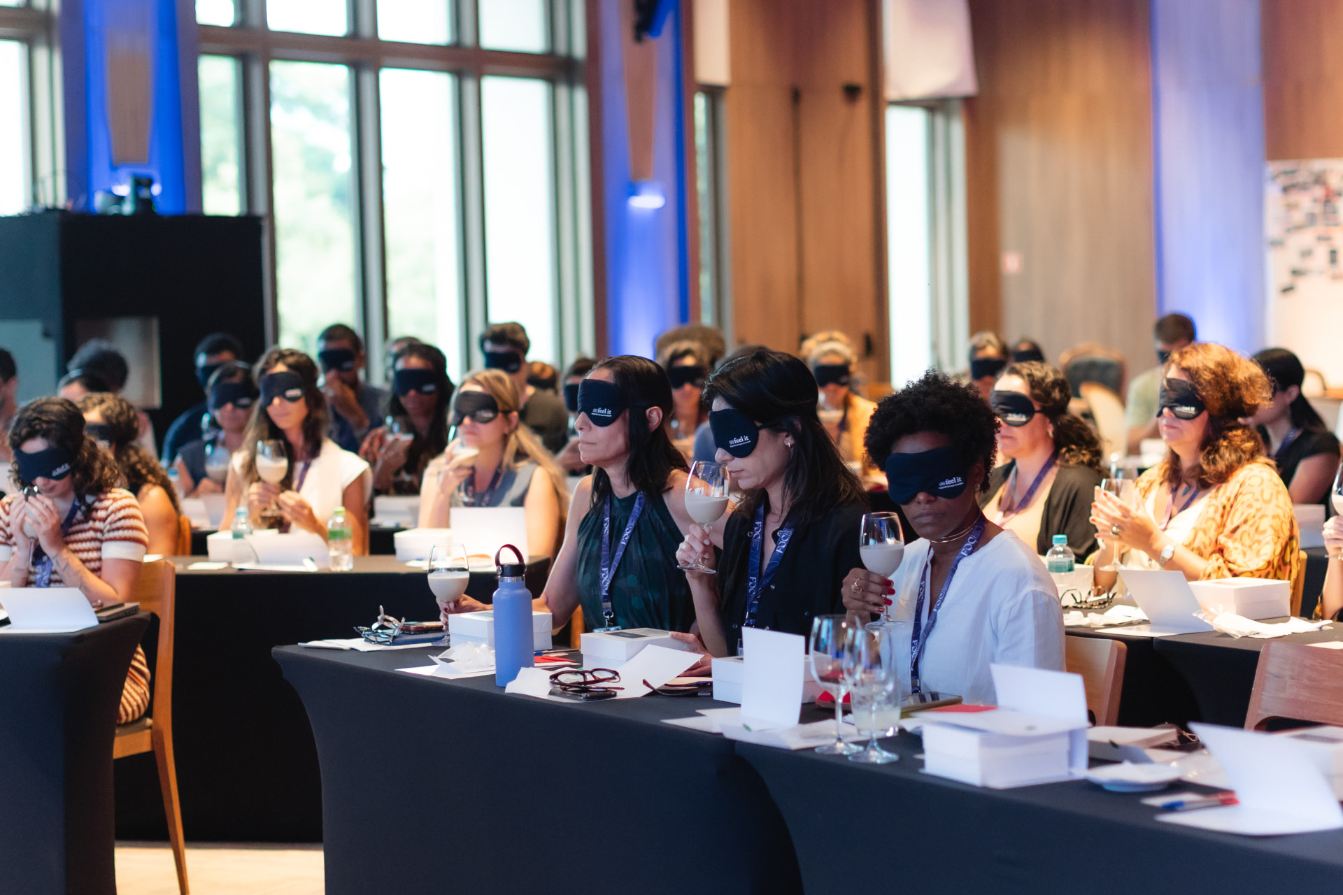Participantes de uma experiência Feel It explorando os sentidos com os olhos vendados