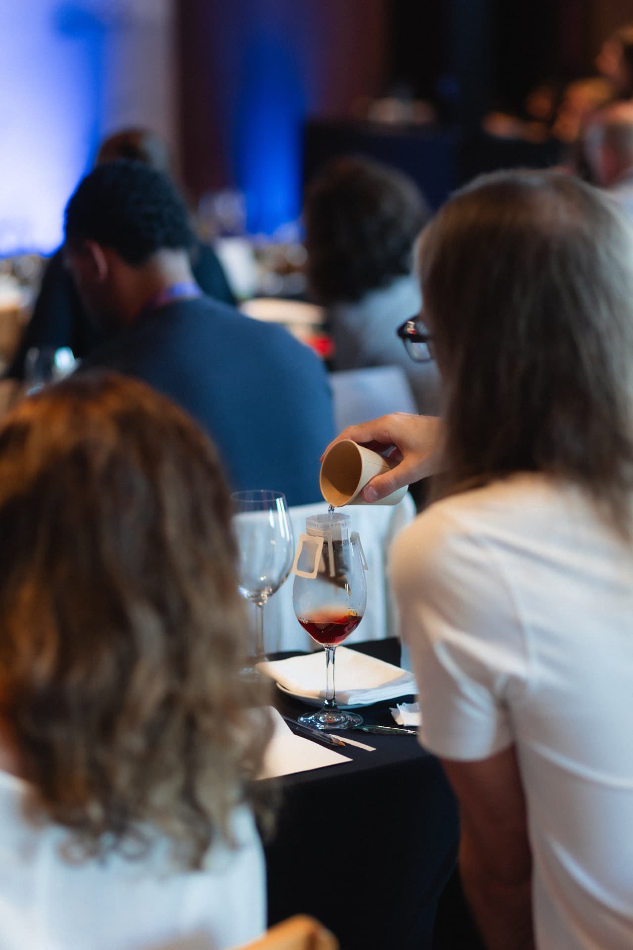 Mão com copo de papel servindo café em uma taça durante a experiência Mindfulness da Feel It